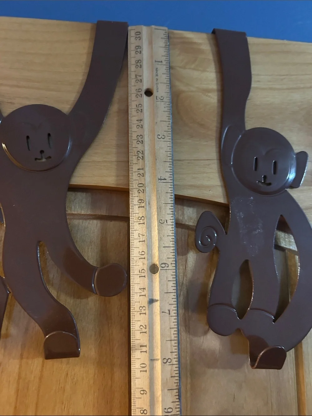 A set of 3 whimsical brown metal monkey over-the-door hooks